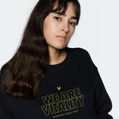 Crewneck Vitality Essentials 2024 noir porté avec zoom sur le logo